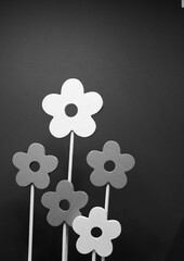 A grayscale shot of wooden flowers