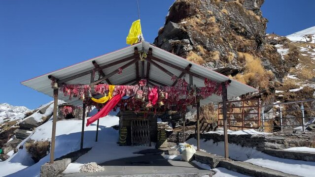 Close-up view of colorful fabrics hanging on gazebo poles in snowy mountains
