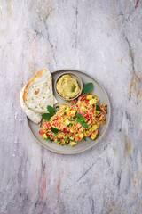 Traditionelles marokkanisches Gemüse Kuskus mit Fladenbrot und Hummus serviert als Draufsicht auf einem Nordic Design Teller