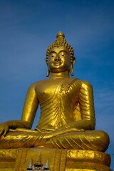 Golden Buddha statue against a blue sky.