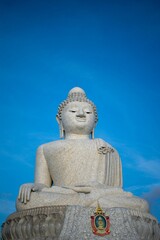 Majestic statue of Buddha against a bright blue sky.