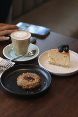 Close up a cup of coffee and bakery on wooden table background