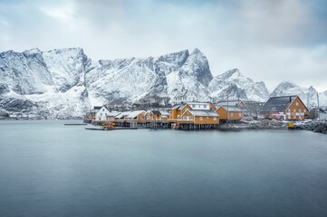 Stunning view of houses by the sea with mountains in the background in Lofoten Islands, Norway