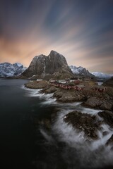 Stunning view of houses by the sea with mountains in the background in Lofoten Islands, Norway