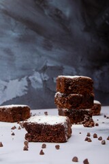 Freshly baked square pieces of chocolate brownie sprinkled with powdered sugar