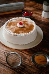 Delicious tres leches cake with ingredients on a wooden table