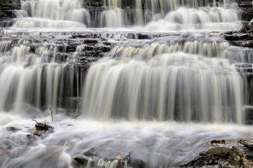 Obraz premium Idyllic river landscape featuring a rocky riverbed and surrounding boulder-strewn banks
