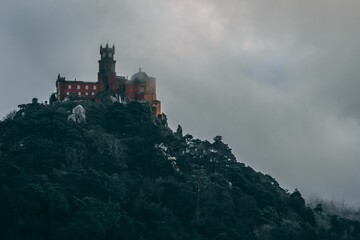 Fototapeta na wymiar A beautiful shot of the Pena Palace on Sintra Mountain on a foggy gloomy day