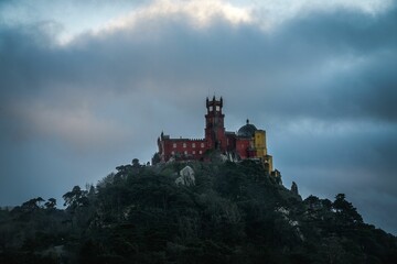Naklejka premium A beautiful shot of the Pena Palace on Sintra Mountain on a foggy gloomy day
