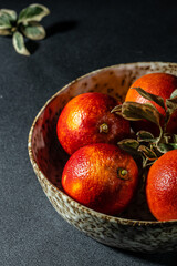 Bloody Sicilian oranges on a grey background, whole and cut sliced, halved with leaves, pattern. top view