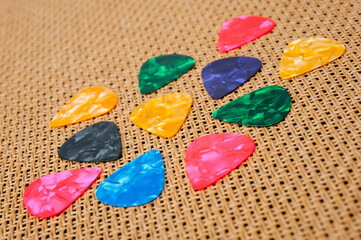 Plastic picks of different colors for playing acoustic or electric guitar.