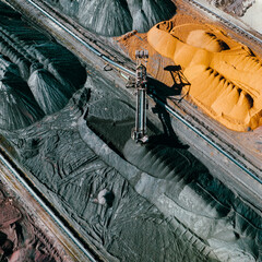 Industrial Site Aerial View. Sorting of Industrial Materials. Surface Mine Colored Minerals and Mining Heavy Equipment. Industrial Background.
