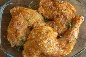 Marinated chicken tights with salt, black pepper, rosemary and paprika ready to be cooked