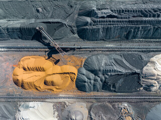 Industrial Site Aerial View. Sorting of Industrial Materials. Surface Mine Colored Minerals and Mining Heavy Equipment. Industrial Background.