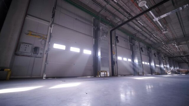 There are automatic gates at a large warehouse. The gates are used for loading cargo from large trucks.