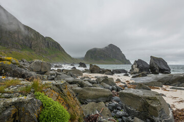 View on a rocky beach on Vaeroy island ( Værøy ) on Lofoten archipelago with a moody stormy sky. Boulders, rocks, Norway, wilderness. Bad weather. day, summer.