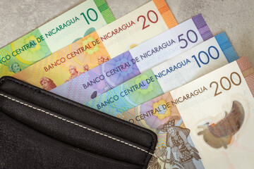 Nicaragua money, various banknotes, black stylish wallet, close up, Nicaraguan Cordobas currency