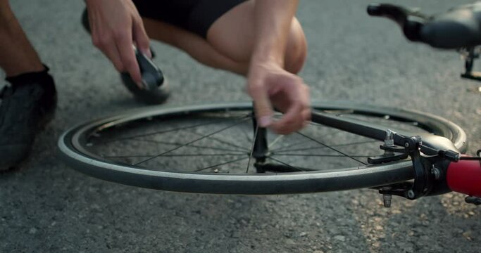 young mna's hands checkinh tire of bike, sportsman touching the weel of bicycle, close up cropprd slow motion video. repairing a bicycle tube, wheel. Inflates the tube with a pump.