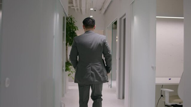Back view unknown businessman entrepreneur ceo employer hurry run on business meeting with partners in office busy man go in company hallway checking hour on wristwatch late time management lateness