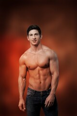 Fototapeta premium Young muscled man posing is studio.