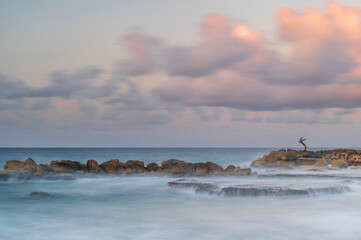 Ocean water, cascading over rocks and reef, on the shoreline of Curacao, in the Caribbean, at sunrise.