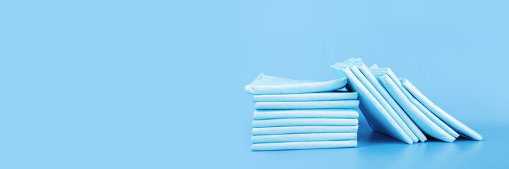 urine diaper napkin, dog absorbent pad banner, absorbent diaper on blue background © yta
