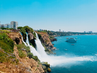 Fototapeta premium Duden waterfall in Antalya, Turkey. Water falls drop off rocky cliff directly into Mediterranean sea in sunny summer day