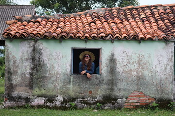 Turista na janela de casa pantaneita em Barão de Melgaço, pantanal do mato grosso 