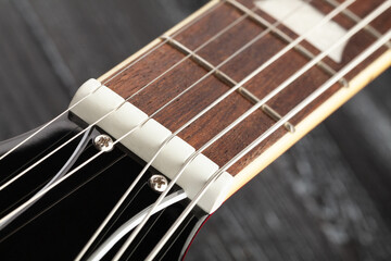 electric guitar nut on wood background
