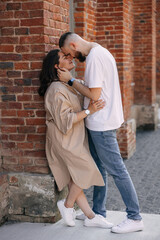 A love couple enjoying a walk in the courtyard of the old city. Against the background, red brick walls. selective focus