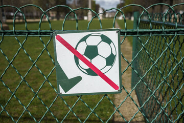 No football allowed sign on a fence in a park