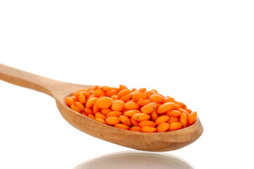 Red lentils with wooden spoon, macro, isolated on white background.