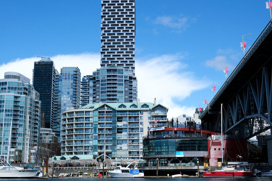 Bridge to greenville water bus passing under the bridge Nature Canada Vancouver Pacific Ocean Pier and pillars on the pier Granville Island aquabus Skyscrapers 