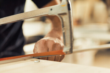 Carpenter precisely stops hand saw with thumb and index finger