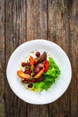 Fried liver with apples and onion on wooden table
