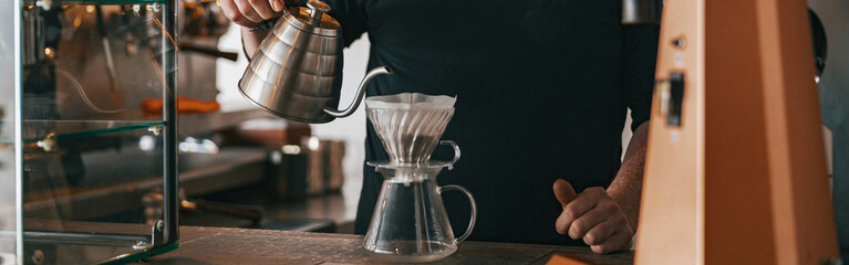 Hand drip coffee, Barista pouring water on coffee ground with filter in cafe