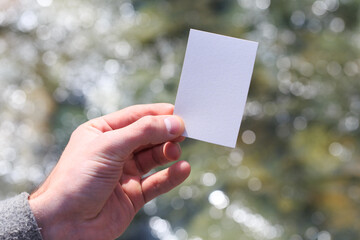Mockup of a blank white business card in the hand of a muchin against the background of water. For your business card design. Branding Mock up.