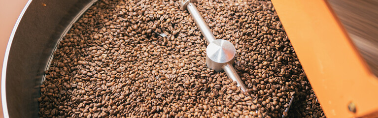 Close up of coffee roasting machine with coffee beans in small coffee manufacturing