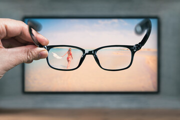 Classic glasses in front of TV screen. Glasses for viewing a stereo image. Protective glasses from...