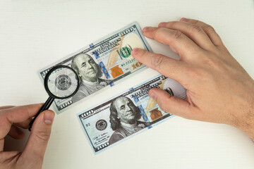 view money under a magnifying glass. Counterfeiter forges banknotes. Fake concept. Fake money American dollars, magnifier. watermark, water mark. search for counterfeit bills - obrazy, fototapety, plakaty