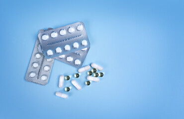 The concept of medicine. A set of pills. a set of medicines. Various capsules. on a blue background, the concept of pills, buying medicines and shopping.