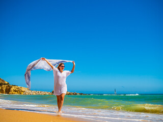 Beautiful woman walking on sunny beach
