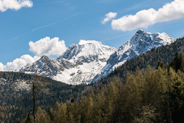 Snowy mountains with blue heaven and big clouds