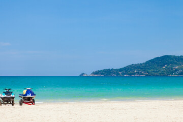 Beautiful Patong beach in Phuket, Thailand with white sand, turquoise water, jet skis and palm trees