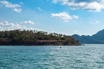 Picturesque place in thailand on phuket island view from rawai beach pier to peninsula with palm trees and stones
