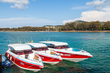 Speed boats moored to the pier of rawai beach in thailand to transport tourists to the phi phi...