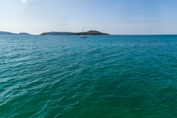 Obraz premium Scenic place in thailand on phuket island view from pier rawai beach island with big expanse of green water and yacht