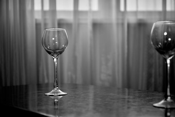 An empty glass wine glass in a gray room at home