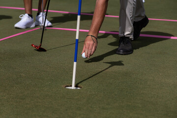 Golf instructor teaches how to place the ball on the grass