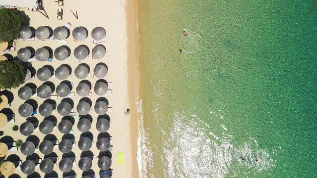 Skiathos beach with many beach umbrellas, aerial view